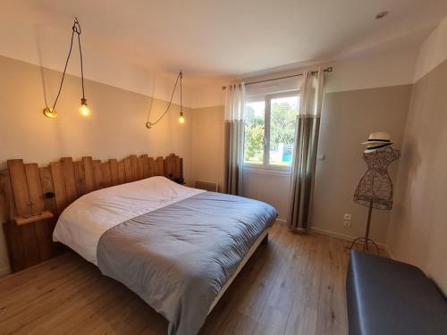 Un dormitorio con una cama grande y una ventana en JOLIE MAISON AVEC PISCINE CHAUFFEE EN CAMPAGNE, en Le Perrier