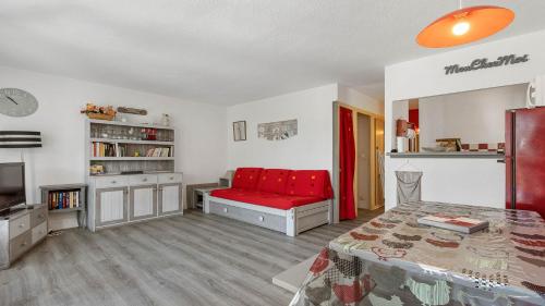 - une chambre avec un canapé rouge dans l'établissement Port La Roquille- 124- Appart proche mer- 6 pers, au Cap d'Agde