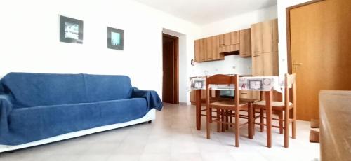 sala de estar con sofá azul y mesa en Appartamenti Giglio Castello, en Isola del Giglio