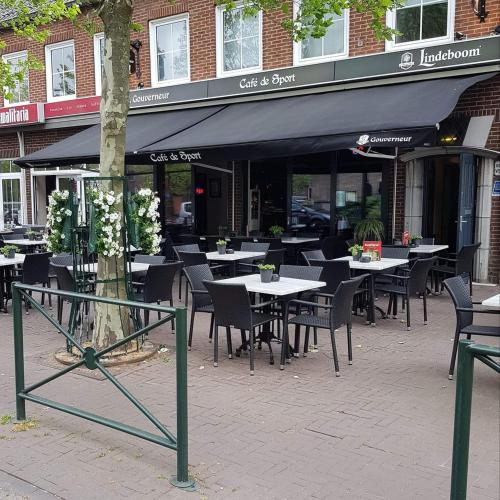a restaurant with tables and chairs in front of a building at Hotel Café de Sport in Velden
