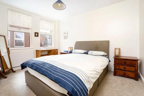 een slaapkamer met een bed, een nachtkastje en 2 ramen bij 1BR Retreat near Twickenham Stadium in Twickenham
