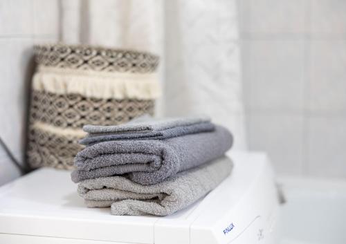 un montón de toallas sentadas en un mostrador en un baño en Apartment TEATAR Tuzla, en Tuzla
