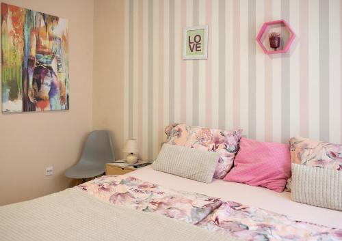 a bedroom with a bed and a pink and white striped wall at Apartment TEATAR Tuzla in Tuzla