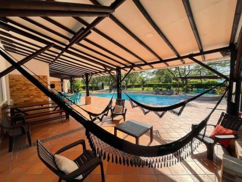 um pátio com redes de descanso e uma piscina em Quinta Morichalito em Villavicencio