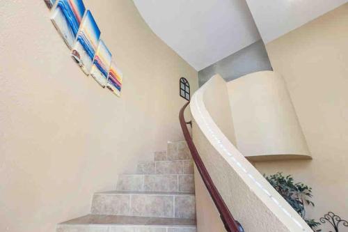 a staircase in a house with surfboards on the wall at The Cool Cactus Condo with Pool and Jacuzzi in Tempe