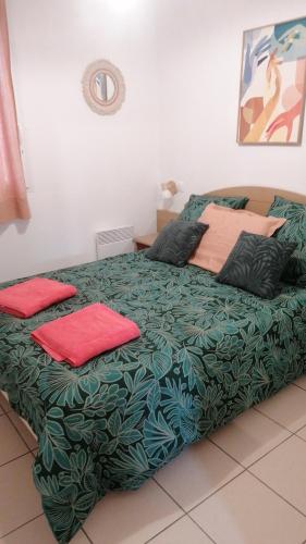 - un lit vert avec 2 oreillers rouges dans l'établissement Chalet T3 Nature Piscine Tennis, à Ondres