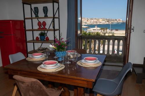 a dining room table with a view of the ocean at Le Maree Deluxe Apartment by Dimore Trinacria in Siracusa