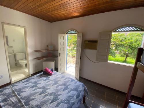 a bedroom with a bed and a bathroom with a window at BUONA SORTE in Lençóis