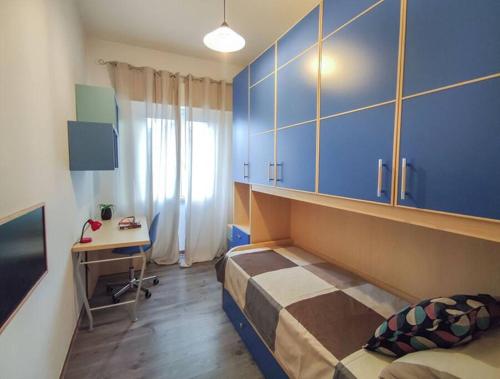 Schlafzimmer mit einem Bett und einem Schreibtisch sowie blauen Schränken in der Unterkunft Ampio Quadrilocale 8 Pax vista mare in San Benedetto del Tronto