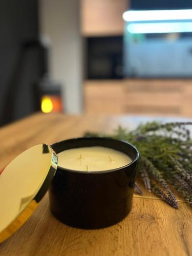 a candle in a black cup on a table at Wellness Chata Hideaway se saunou a vířivkou in Třebechovice pod Orebem