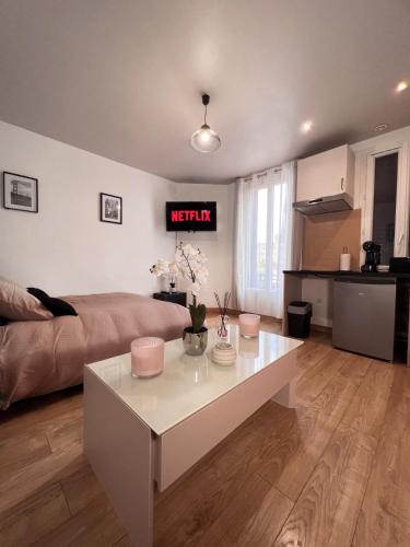 ein Wohnzimmer mit einem Sofa und einem weißen Couchtisch in der Unterkunft Studio cosy proche du lac d'Enghien in Soisy-sous-Montmorency