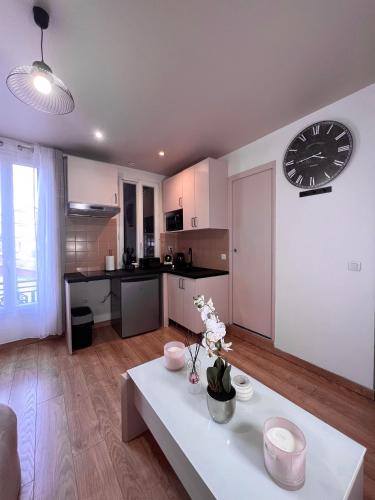 - un salon avec une grande horloge murale dans l'établissement Studio cosy proche du lac d'Enghien, à Soisy-sous-Montmorency