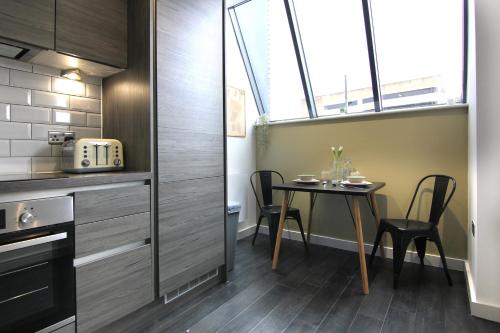eine kleine Küche mit Tisch und Fenster in der Unterkunft West Bar Penthouse FREE Parking in Sheffield