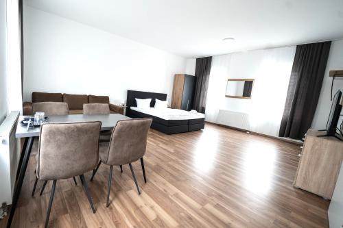 a living room with a table and chairs and a couch at Hotel Zur alten Stadtkellerei Leipzig in Leipzig