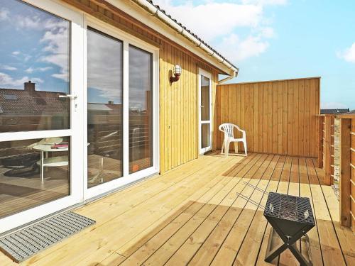 a wooden deck with a table and a chair at 6 person holiday home in Thisted in Nørre Vorupør