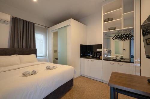 a bedroom with a large white bed and a table at Dema Luxury Suites - Lekka E3 in Athens