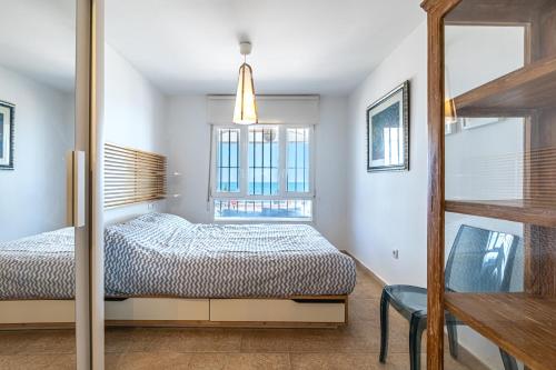 a bedroom with a bed and a window at Beachfront Bliss: Apartamento a pie de playa in Alicante
