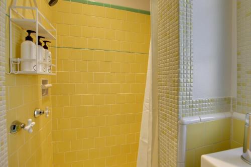 a bathroom with yellow tiles and a shower at Charming Spring Valley Retreat with Private Pool! in Spring Valley