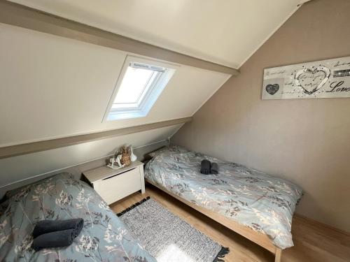 Habitación pequeña con 2 camas y ventana en Vakantiewoning aan de Kust 21, en Egmond aan Zee