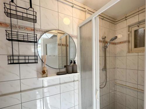 uma casa de banho com um chuveiro e um espelho. em Vakantiewoning aan de Kust 21 em Egmond aan Zee