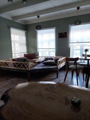 a living room with two beds and a table at Guest House Ruh Achari in Sheki