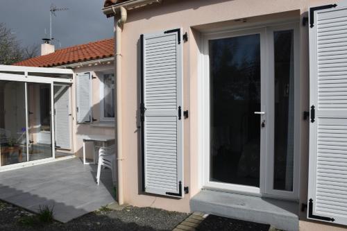 ein Haus mit weißen Türen und einer Terrasse in der Unterkunft TY BIHAN in La Bernerie-en-Retz