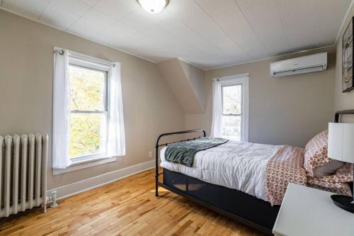 ein Schlafzimmer mit einem Bett und zwei Fenstern in der Unterkunft Eagles Landing in La Crosse