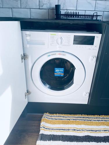 a washer and dryer in a kitchen with a rug at II comfortable room, Shared House in Bristol