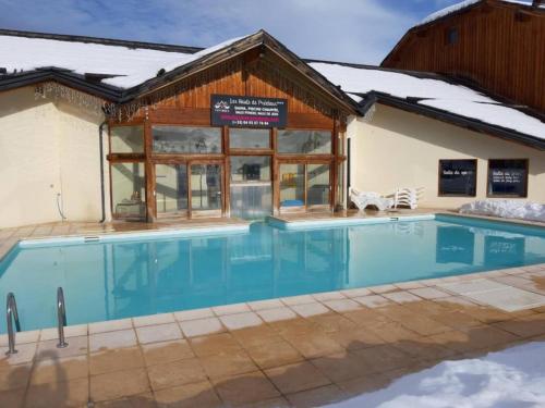 a swimming pool in front of a building with a house at La Flèche D'Orres, 6 pers, 40m2, centre station in Les Orres