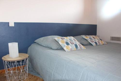 łóżko z 2 poduszkami i niebieską ścianą w obiekcie La Flèche D'Orres, 6 pers, 40m2, centre station w mieście Les Orres
