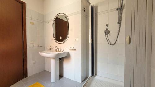 a bathroom with a sink and a shower with a mirror at Residenza Le Orchidee in Galtellì
