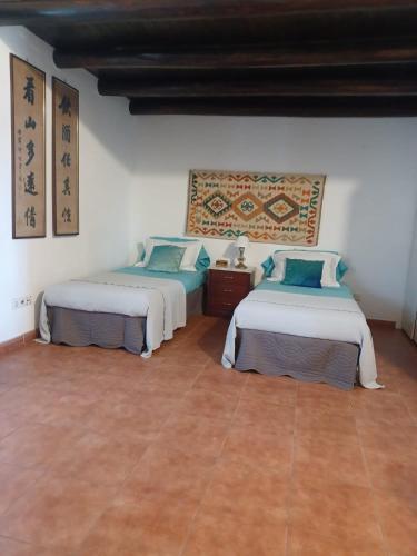 two beds in a room with a tiled floor at Casa Bril in Cumeada