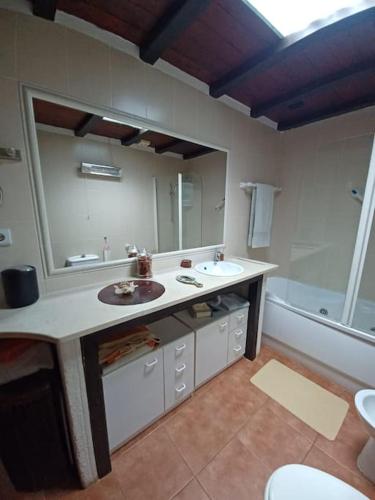 a bathroom with a sink and a mirror and a tub at Casa Bril in Cumeada