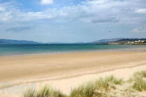 a sandy beach with the ocean in the background at Ardmore Cottage - Failte Ireland Quality Assured in Muff