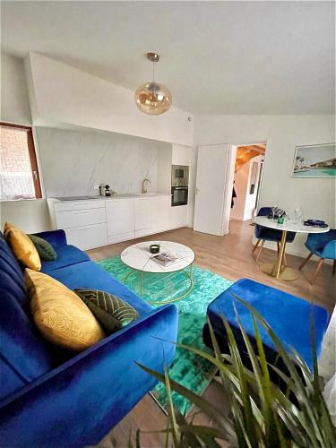 a living room with a blue couch and a table at The SPA - Voyage des sens in Amiens