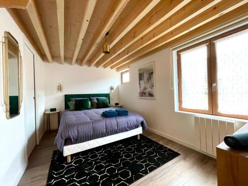 a bedroom with a bed and a wooden ceiling at The SPA - Voyage des sens in Amiens