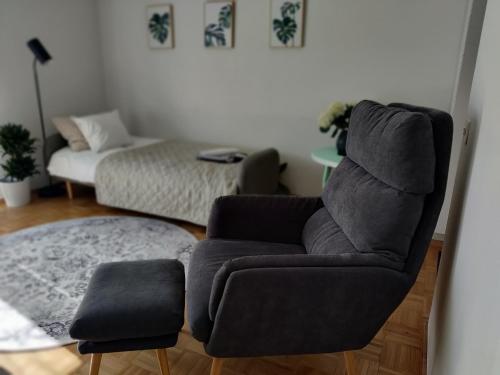 - un salon avec une chaise et un canapé dans l'établissement Niinivaara apartment saunallinen ja ilmastoitu majoitus, à Joensuu