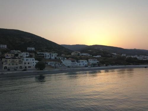 a view of a town with the sun setting over the water at Beachfront House Agia Pelagia Kythira in Agia Pelagia Kythira