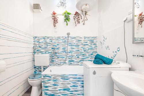 uma casa de banho com azulejos azuis e brancos na parede em Sunny Dots Apartment em Budapeste