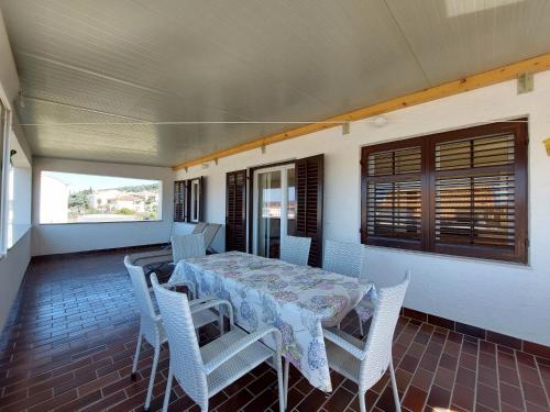 a dining room with a table and chairs on a porch at Apartment Neda in Punat