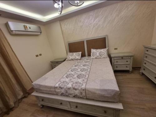 una camera con un grande letto e due comodini di شقة مفروشة فخمه لهواة الذوق الرفيع فقط a Il Cairo