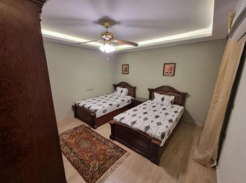 una camera con 2 letti e un ventilatore a soffitto di شقة مفروشة فخمه لهواة الذوق الرفيع فقط a Il Cairo