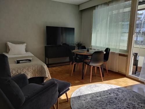 a living room with a couch and a table and a tv at Niinivaara apartment saunallinen ja ilmastoitu majoitus in Joensuu