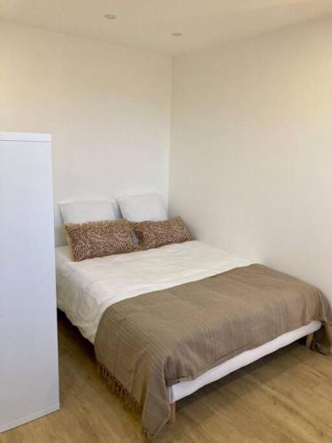 Ce lit se trouve dans un dortoir doté d'un mur blanc. dans l'établissement Appartement Bordeaux Centre - Grand Théâtre, à Bordeaux