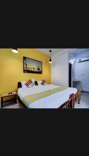 a bedroom with a large bed with yellow walls at Parppidam Residency in Trippapur