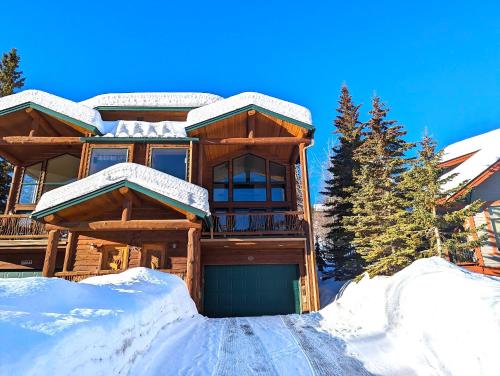 a log cabin in the snow with a garage at Moose Tree Lodge in Whitefish