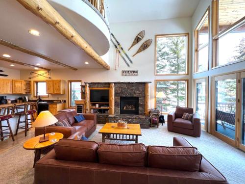 a living room with leather furniture and a fireplace at Moose Tree Lodge in Whitefish