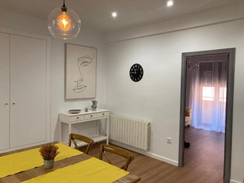 ein Esszimmer mit einem gelben Tisch und Stühlen sowie ein Zimmer mit einem Fenster in der Unterkunft Casa Ferma in Teruel