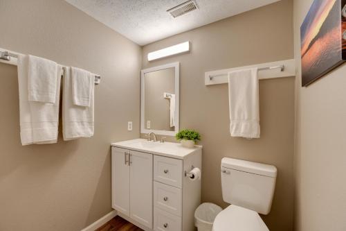 a bathroom with a toilet and a sink and a mirror at Reeds Spring Retreat with Lakeview Deck and Grill in Reeds Spring