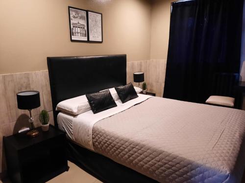 Schlafzimmer mit einem Bett mit einem schwarzen Kopfteil in der Unterkunft Hotel La Terminal in San Miguel de Tucumán